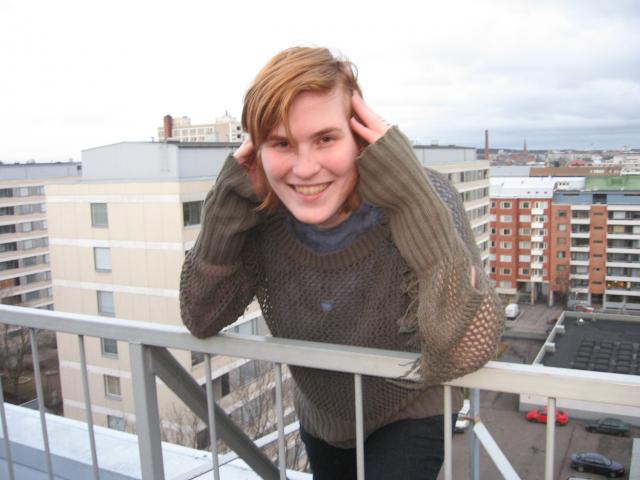 Maailman katolla androgyynirokkarinarkkariluukissa kaiteen ulkopuolella nojailemassa marraskuussa 2008 (asetelma, idea ja poseeraus: Krisse Sydän, kuva: Stanzara). Oli hiton kylmä ja tuuli, mutta hymy ei hyytynyt :)