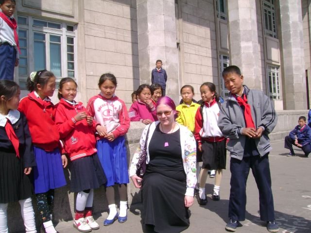 Toimittaja pohjoiskorealaisten lasten keskellä.