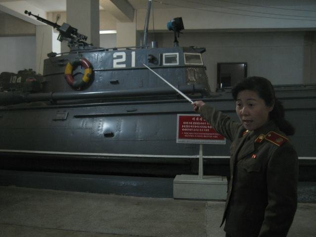 Opas esittelee Korean sodassa käytettyä kalustoa. Esillä oli myös mm. tuhottuja jenkkihelikoptereita ja sankaripuu.