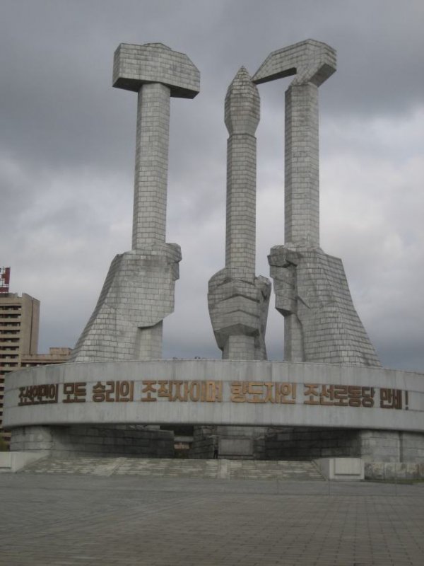 Puolueen perustamisen kunniaksi pystytetty patsas. Neukuista tuttujen sirpin (viljelijät ja maataloustyöläiset) ja vasaran (tehdastyöläiset) oheen on Pohjois-Koreassa lisätty sivellin (intelligentit).