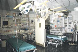 Ensihoitohuoneen kaapeissa on muun muassa lääkkeitä, verta, sidetarpeita, kanyyleita, lämpöpeitteitä, neuloja. Seinällä röntgentaulu, jossa hoidettavan potilaan tiedot.