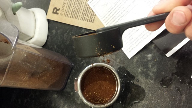 Tulikohan tähän nyt riittävästi kahvijauhoja. No mausta se sitten selviää. Pro-vinkki: Esilämmitä kuppi ja metalliosat, niin saat espresson lämpimämpänä. Lämmitin itse kiehuvalla vedellä, siksi pöytä on märkä.