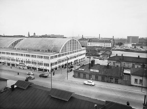 Kampin aluetta Fredrikinkadulta päin kuvattuna vuosina 1938-39. Tennispalatsia ympäröivät puurakennukset Kampintorilla ja taustalla ovat linja-autoasema, Maitokeskus ja Postitalo.