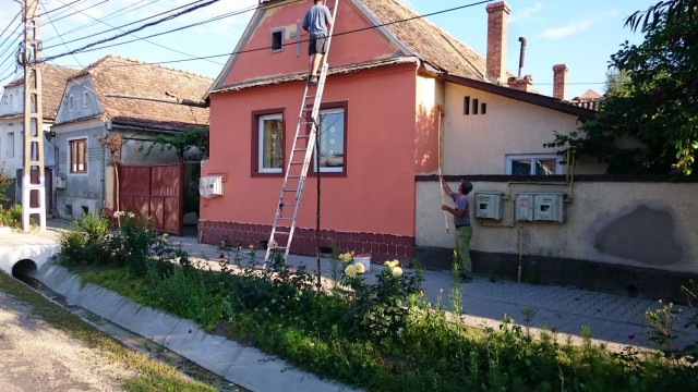 Maalari maalaa taloa Romaniassa.