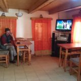 Romanialainen istuskelee kahvilassa. Televisiosta tulee paikallista musiikkia.