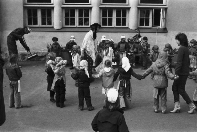 Vironniemen päiväkodin lapsia ja aikuisia harjakaisasuissaan aloittamassa piiritanssia vappujuhlissa Virkkulan päiväkodin pihalla 1982