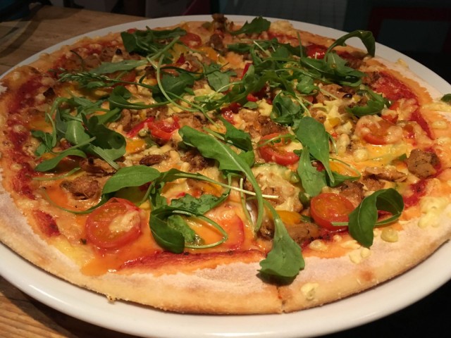 Lost in Helsingin vegaanisessa pizzassa on nyhtöhernettä, tomaattia, paprikaa, rucolaa ja vegaanista juustoa.
